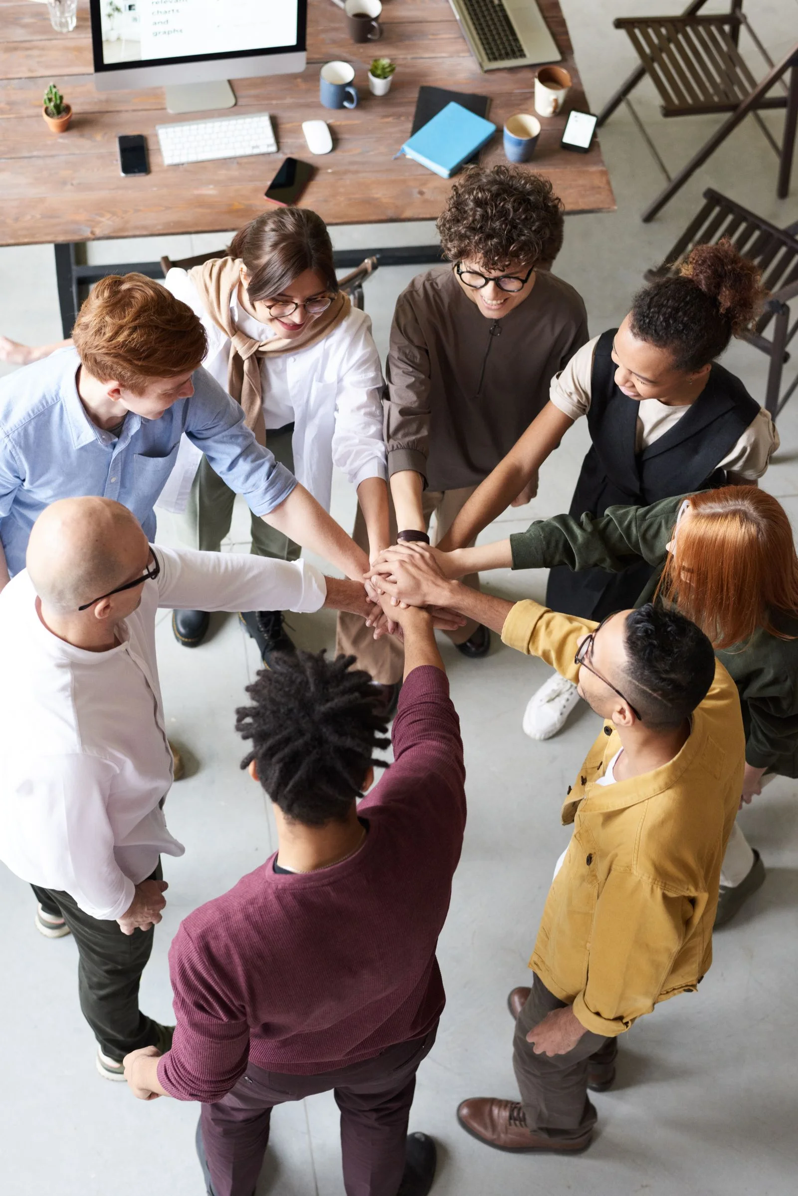 A group joining their hands together around a table